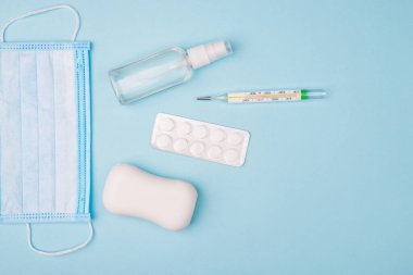 Kurtar kendini. Tepenin üstünde cerrahi maske sabunu cıva termometresi ve arka planda boş fotokopi alanı ile izole edilmiş eller için sprey ile küçük bir şişe vardı.