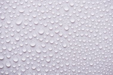 Beyaz arkaplandaki su damlalarının yukarıdaki görüntüsü