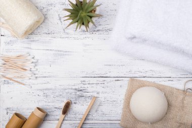 Tepede beyaz ahşap zemin üzerinde izole edilmiş eko banyo ürünlerinin fotosu var.