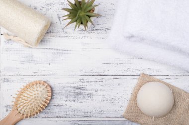 Yukarıdan bakıldığında eko banyo ürünlerinin fotoğrafı ve beyaz ahşap arka planda izole edilmiş sulu bir sıvı.