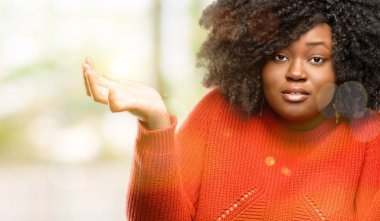 Güzel Afrikalı kadın şüphe ifade, şaşırtmak ve belirsiz gelecekte shrugging omuzlar, açık kavramı, merak ediyorum