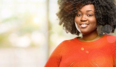 Güzel Afrikalı kadın kendinden emin ve mutlu gülüyor, açık büyük bir doğal gülümseme ile