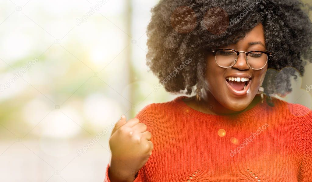 Beautiful african woman happy and excited celebrating victory expressing big success, power, energy and positive emotions. Celebrates new job joyful, outdoor