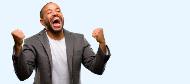 Sakal mutlu ve heyecanlı kutluyor zafer büyük başarı, güç, enerji ve olumlu duygular ifade olan Afrika kökenli Amerikalı adam. Yeni iş neşeli üzerinde mavi arka plan izole kutluyor