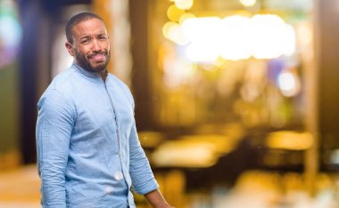 Afrika kökenli Amerikalı adam üzgün ve üzgün ifadeyle, geceleri mutsuz sakallı