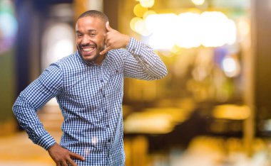 Afrika kökenli Amerikalı adam sakallı mutlu ve heyecanlı bana jest telefon gibi geceleri şeklinde el ile gösteren arama yapma