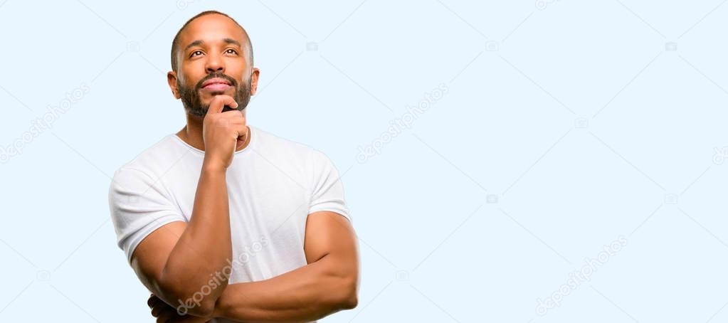 African american man with beard thinking and looking up expressing doubt and wonder isolated over blue background