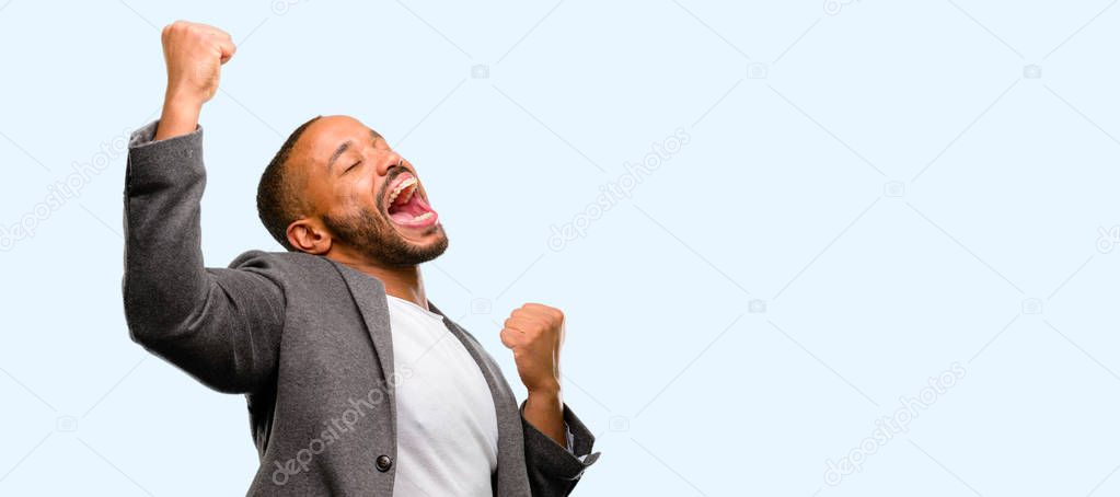 African american man with beard happy and excited celebrating victory expressing big success, power, energy and positive emotions. Celebrates new job joyful isolated over blue background