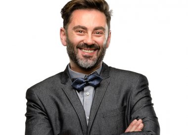 Orta yaş adam, sakal ve papyon kendinden emin ve mutlu bir büyük doğal ile çapraz kollu smile beyaz arka plan üzerinde izole gülüyor