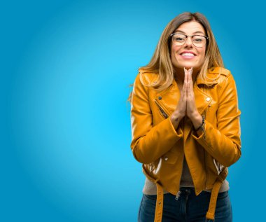 El ele tutusun jest, umut ifadelerini belirtti ve kavramı, mavi arka plan lütfen dua etmenin güzel genç kadın