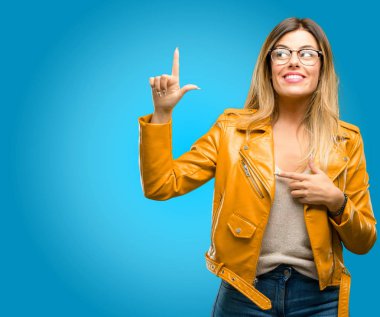 Güzel genç kadın mutlu ve ifade wow jest, mavi arka plan işaret tezahürat