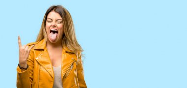 Güzel genç kadın Rock simge elle yapma, bağırarak ve dilini çıkarmış kutluyor