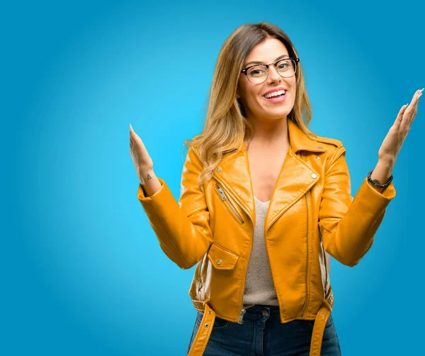 Beautiful young woman confident and happy with a big natural smile welcome gesture, blue background