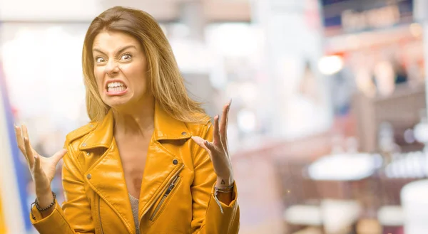 Beautiful young woman terrified and nervous expressing anxiety and panic gesture, overwhelmed at restaurant