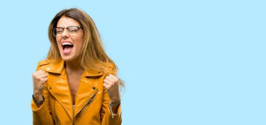 Beautiful young woman happy and excited celebrating victory expressing big success, power, energy and positive emotions. Celebrates new job joyful clipart
