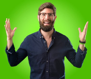 Mutlu ve ifade wow jest yeşil arka plan üzerinde tezahürat büyük sakallı genç hipster adam