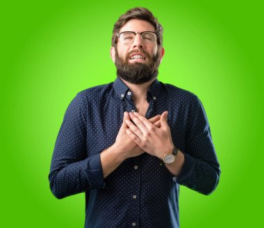 Kalp, elleriyle büyük sakallı genç hipster adam yeşil arka plan üzerinde sevgi ve sağlık kavramı ifade