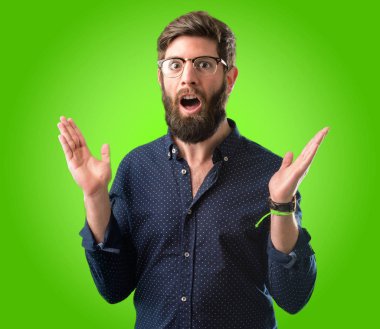 Mutlu ve ifade wow jest yeşil arka plan üzerinde tezahürat büyük sakallı genç hipster adam