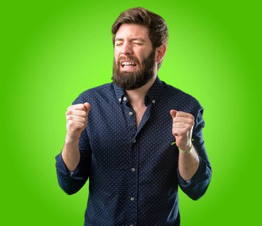 Mutlu ve ifade wow jest yeşil arka plan üzerinde tezahürat büyük sakallı genç hipster adam