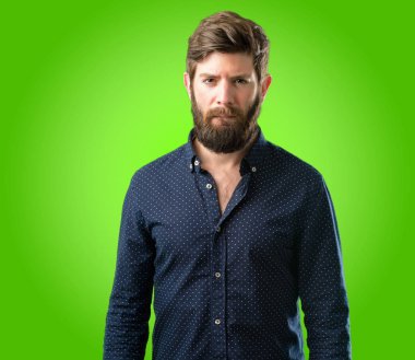 Büyük sakal şüphe ifade, adamla genç hipster şaşırtmak ve kavramı, yeşil arka plan üzerinde belirsiz gelecek merak ediyorum