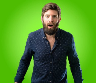 Mutlu ve ifade wow jest yeşil arka plan üzerinde tezahürat büyük sakallı genç hipster adam