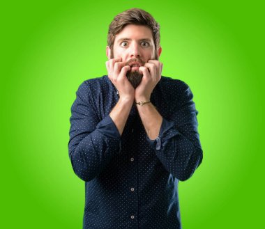 Çok korkmuş ve sinir anksiyete ve panik jest, yeşil arka plan üzerinde bunalmış ifade büyük sakallı genç hipster adam
