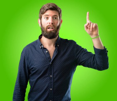 Yeşil arka plan üzerinde yukarıyı büyük sakal mutlu ve tezahürat ifade wow jest adamla genç yenilikçi