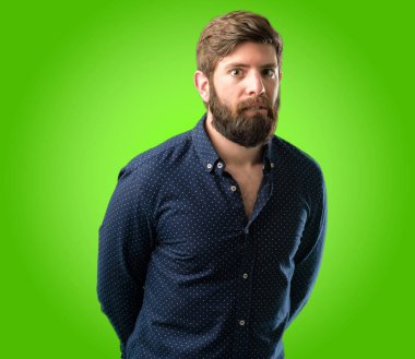 Büyük sakal şüphe ifade, adamla genç hipster şaşırtmak ve kavramı, yeşil arka plan üzerinde belirsiz gelecek merak ediyorum