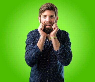 Mutlu ve ifade wow jest yeşil arka plan üzerinde tezahürat büyük sakallı genç hipster adam