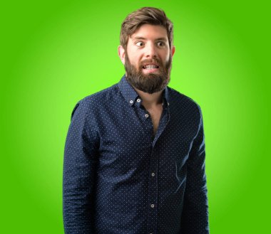 Kendinden emin ve mutlu yeşil arka plan üzerinde gülüyor büyük bir doğal gülümseme ile büyük sakallı genç hipster adam