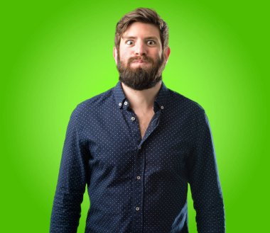 Yanakları şişirme büyük sakallı genç hipster adam yeşil arka plan üzerinde yüz komik yapma eğleniyor