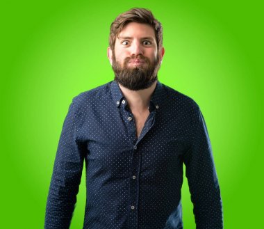 Yanakları şişirme büyük sakallı genç hipster adam yeşil arka plan üzerinde yüz komik yapma eğleniyor