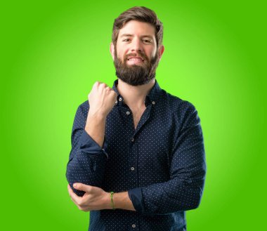 Kendinden emin ve mutlu yeşil arka plan üzerinde gülüyor büyük bir doğal gülümseme ile büyük sakallı genç hipster adam