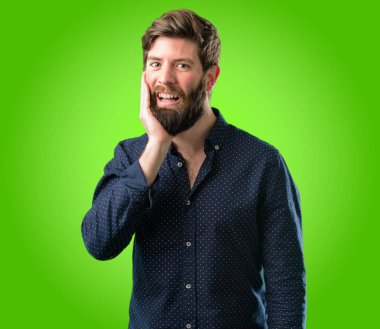 Mutlu ve ifade wow jest yeşil arka plan üzerinde tezahürat büyük sakallı genç hipster adam