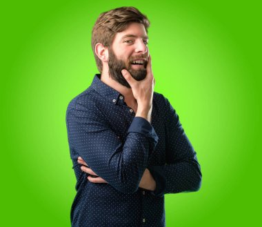 Mutlu ve ifade wow jest yeşil arka plan üzerinde tezahürat büyük sakallı genç hipster adam