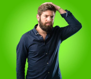 Büyük sakal şüphe ifade, adamla genç hipster şaşırtmak ve kavramı, yeşil arka plan üzerinde belirsiz gelecek merak ediyorum