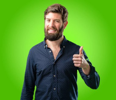 Geniş jest kamera, gibi ifade ve onay için Yaşasın yeşil arka plan üzerinde gösterilen büyük sakal gülümseyen genç hipster adam