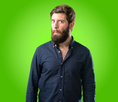 Şüpheci ve memnun olan büyük sakallı genç hipster adam bak ifade güvensizlik, şüphecilik ve şüphe yeşil arka plan üzerinde