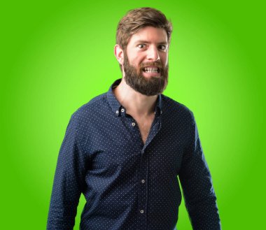 Kendinden emin ve mutlu yeşil arka plan üzerinde gülüyor büyük bir deli gülümseme ile büyük sakallı genç hipster adam