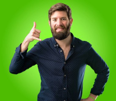 Mutlu ve heyecanlı bana jest telefon gibi yeşil arka plan üzerinde şeklinde el ile gösteren arama yapma büyük sakallı genç hipster adam