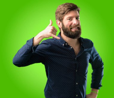 Mutlu ve heyecanlı bana jest telefon gibi yeşil arka plan üzerinde şeklinde el ile gösteren arama yapma büyük sakallı genç hipster adam