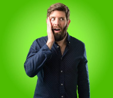 Çok mutlu ve kendinden emin bir büyük gülümseme sürpriz parmak yeşil arka plan üzerinde gösterilen büyük sakallı genç hipster adam