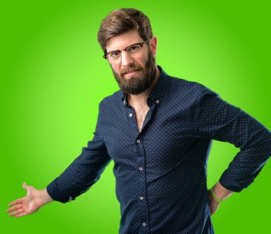 Kendinden emin ve mutlu bir büyük doğal büyük sakallı genç hipster adam gülümseme yeşil arka plan üzerinde girmek için davet