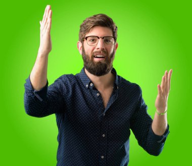 Kendinden emin ve mutlu yeşil arka plan üzerinde bir büyük doğal gülümseme hoş geldiniz hareketi ile büyük sakallı genç hipster adam