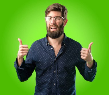 Geniş jest kamera, gibi ifade ve onay için Yaşasın yeşil arka plan üzerinde gösterilen büyük sakal gülümseyen genç hipster adam