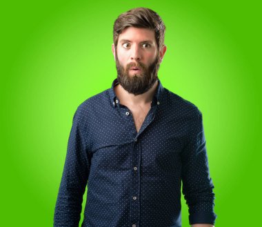 Mutlu ve ifade wow jest yeşil arka plan üzerinde tezahürat büyük sakallı genç hipster adam