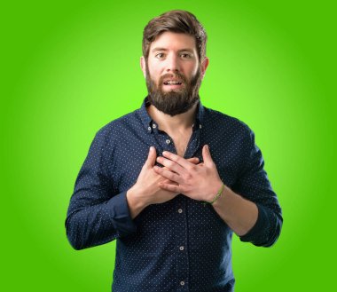 Sevgi ve sempati yeşil arka plan üzerinde göstermek isteyen kalp üzerinde el ele tutuşarak gülümseme büyüleyici büyük sakal sahip genç hipster adam