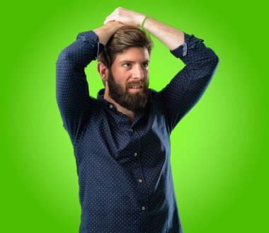 Kendinden emin ve mutlu yeşil arka plan üzerinde büyük bir doğal gülümseme ile büyük sakallı genç hipster adam