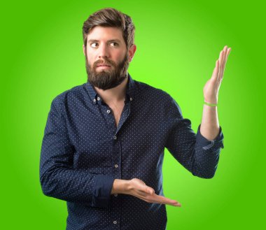 Büyük sakal şüphe ifade, adamla genç hipster şaşırtmak ve kavramı, yeşil arka plan üzerinde belirsiz gelecek merak ediyorum