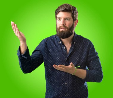 Büyük sakal şüphe ifade, adamla genç hipster şaşırtmak ve kavramı, yeşil arka plan üzerinde belirsiz gelecek merak ediyorum